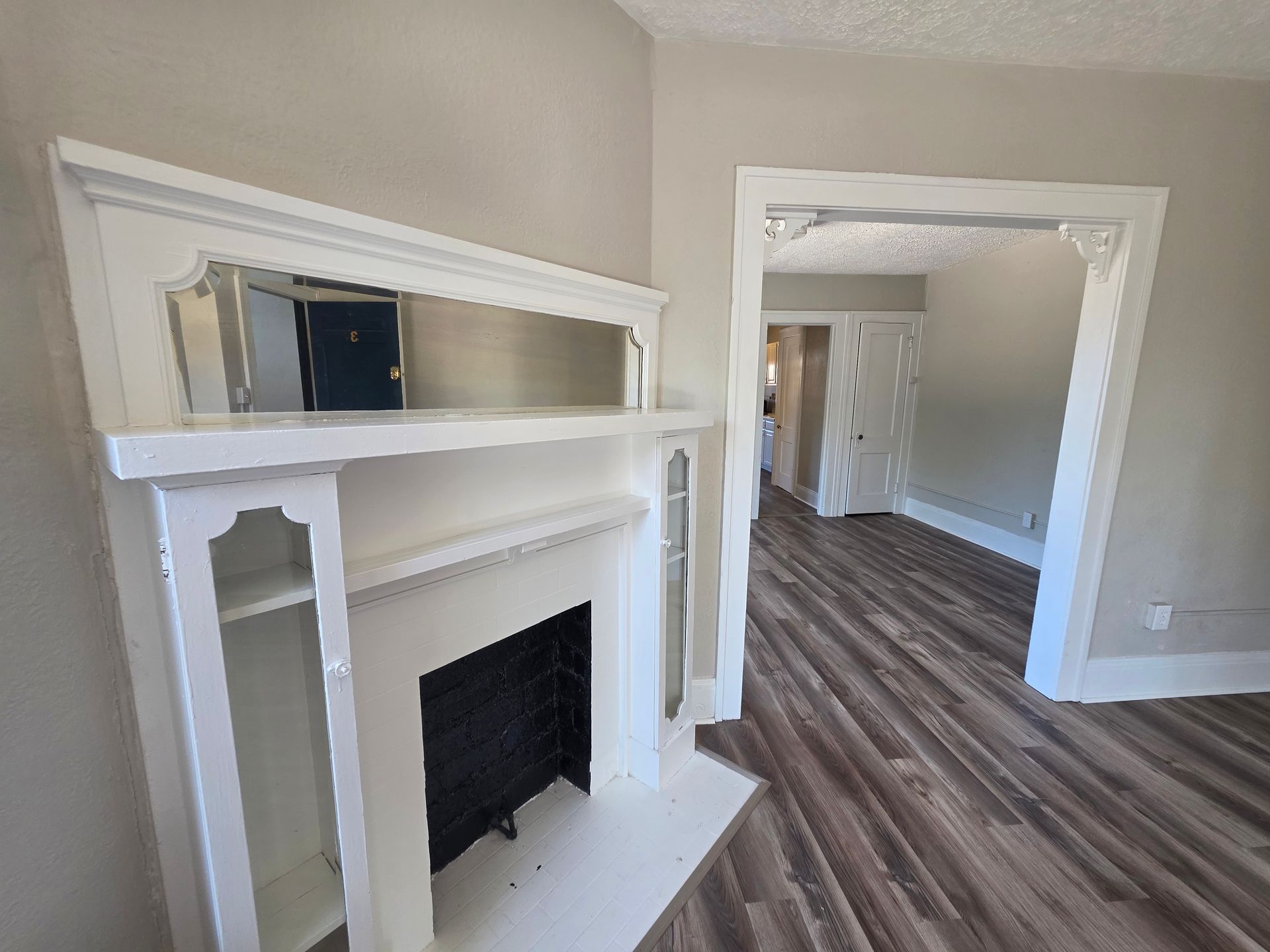 White decorative fireplace and original vintage trim in historic Akron Apartment rental. 