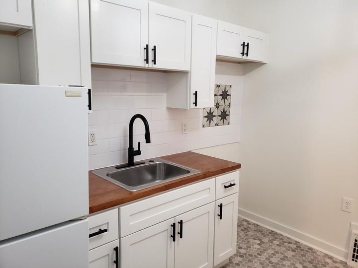 Beautifully renovated kitchen with bright white, soft close cabinetry and butcherblock countertops.