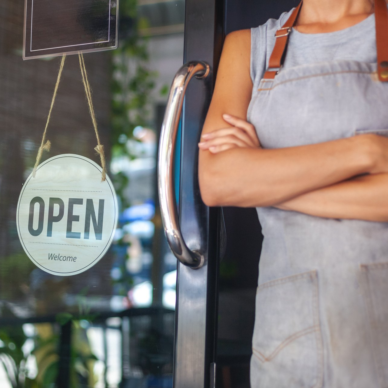 A woman is standing in front of an open sign