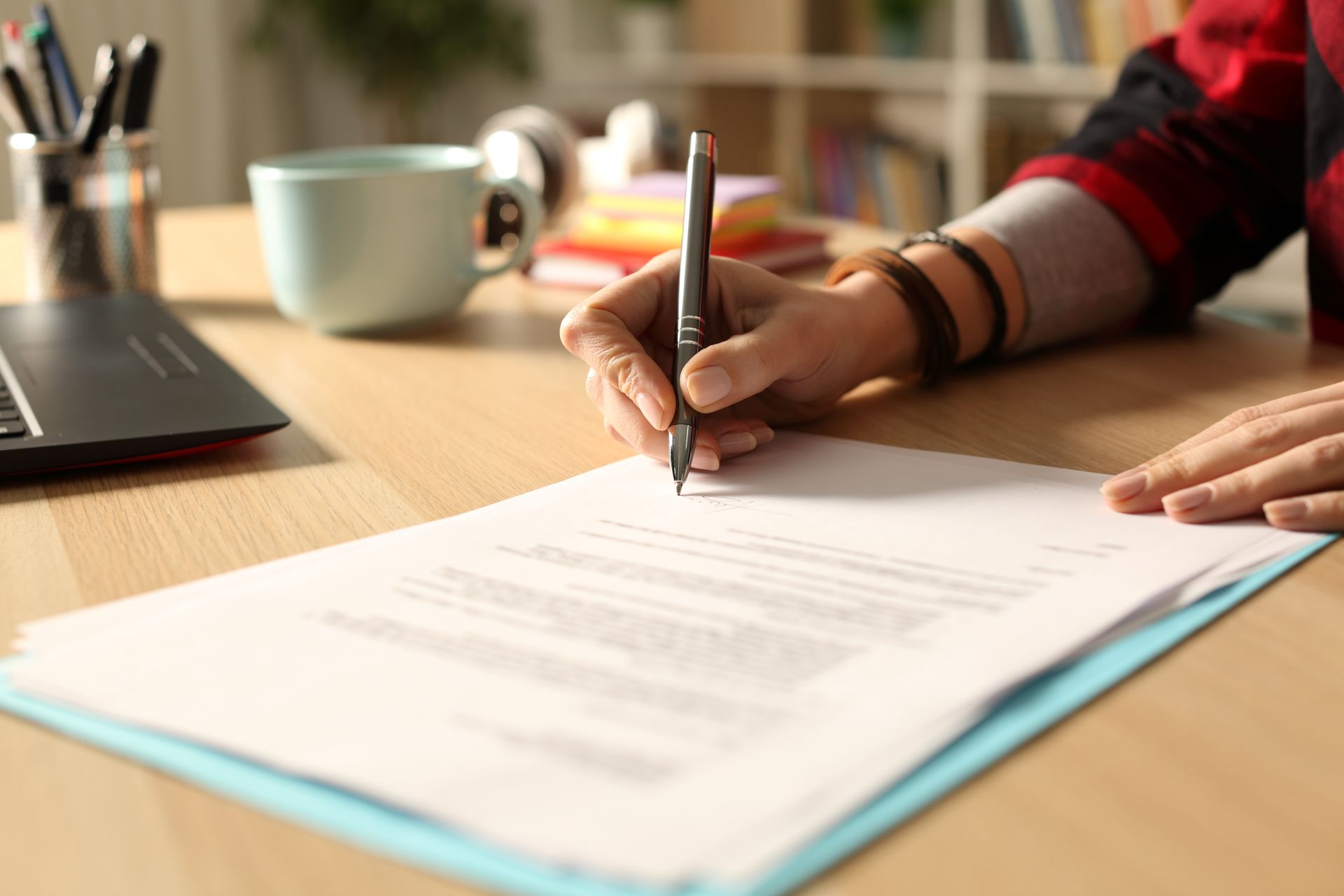 A person is writing on a piece of paper with a pen.