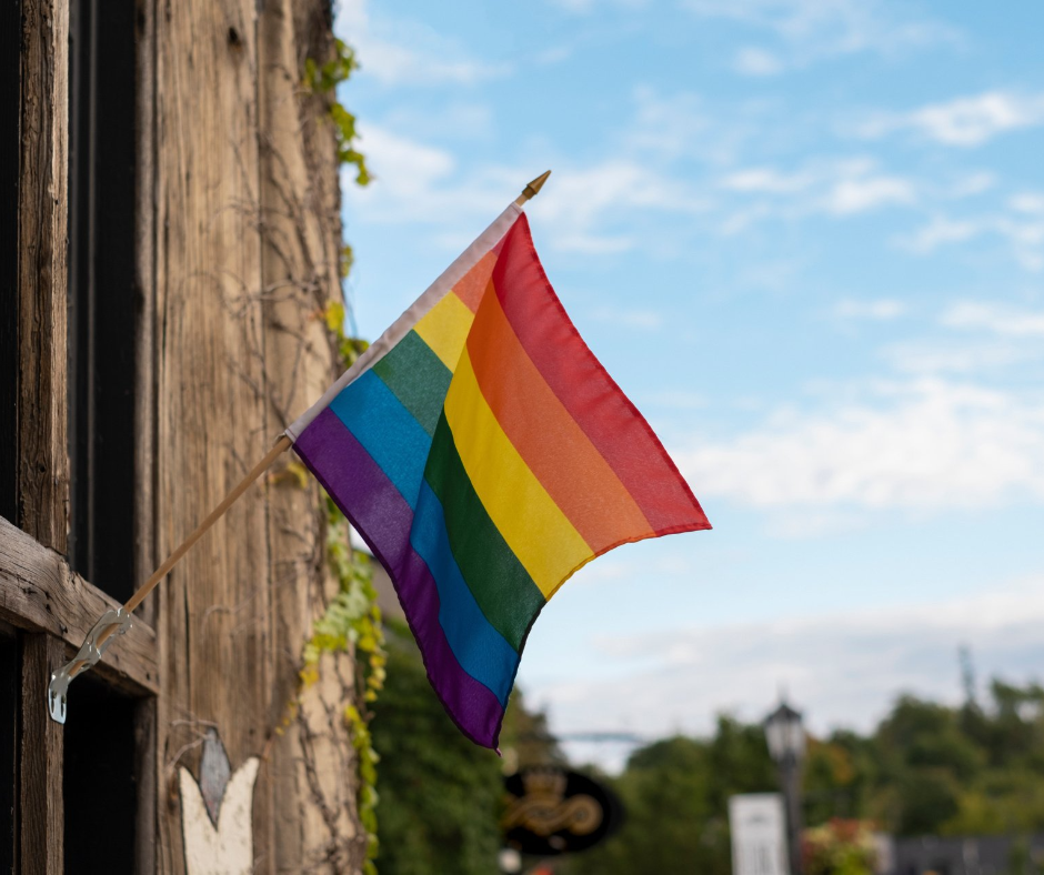 A rainbow flag is hanging from the side of a building