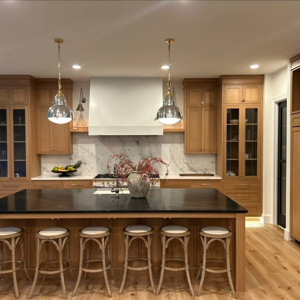 A kitchen with wooden cabinets and a black counter top