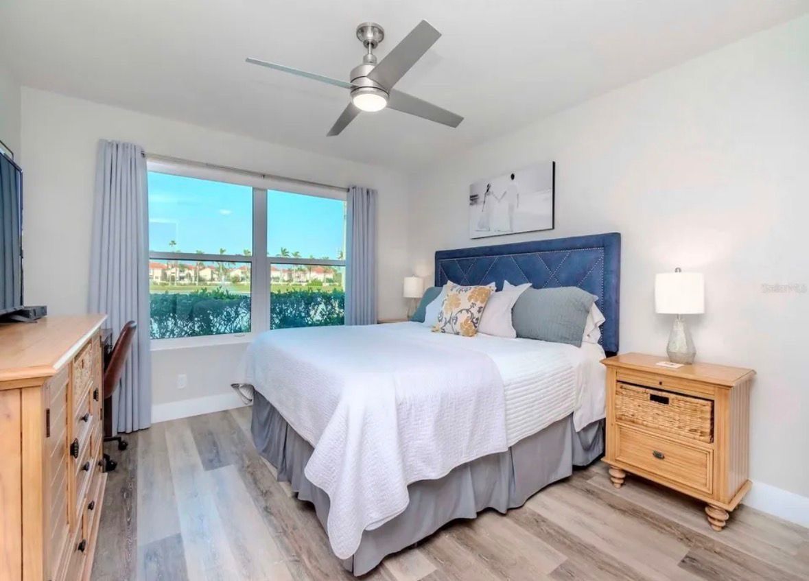 Bright bedroom with floral bedspread, ocean view through sliding doors, and turquoise accents