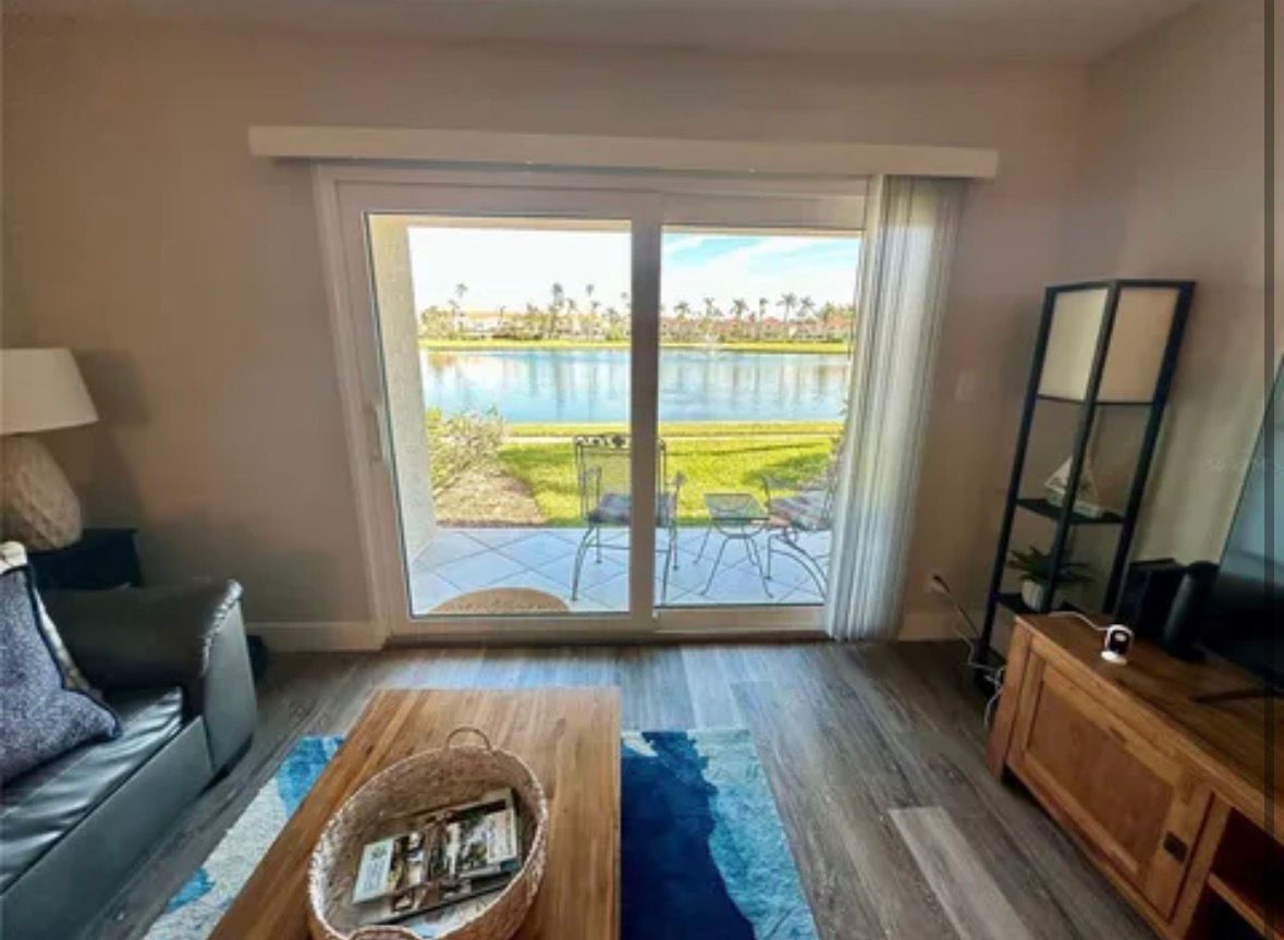 Living room with large sliding glass doors overlooking a lake and city skyline