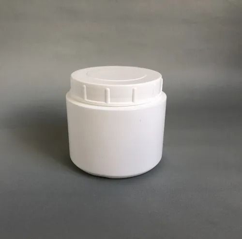 Tarro de plástico blanco con tapa de rosca sobre una superficie gris.