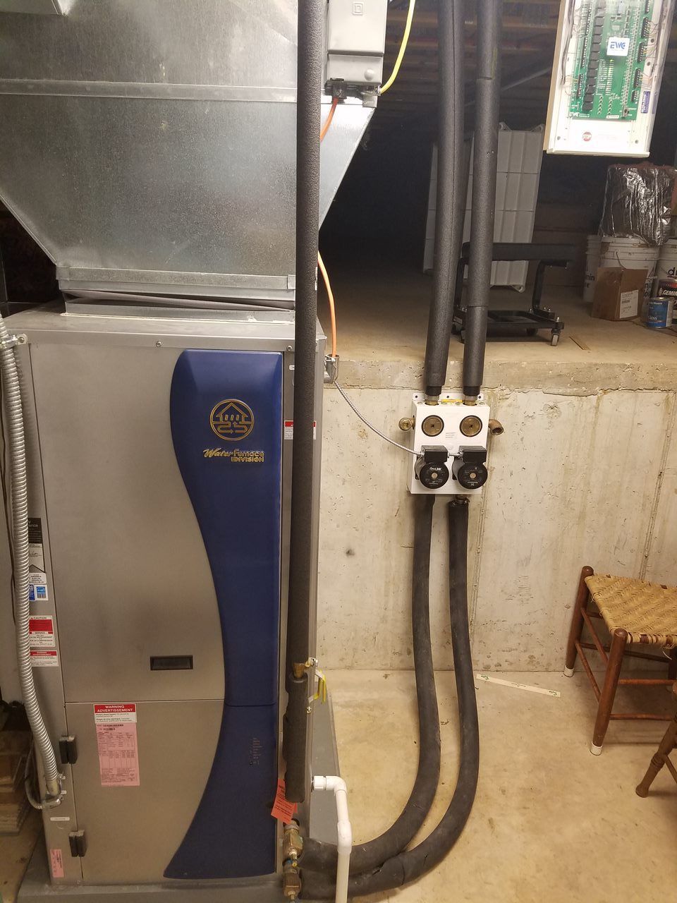 A gray and blue heater is sitting in a basement