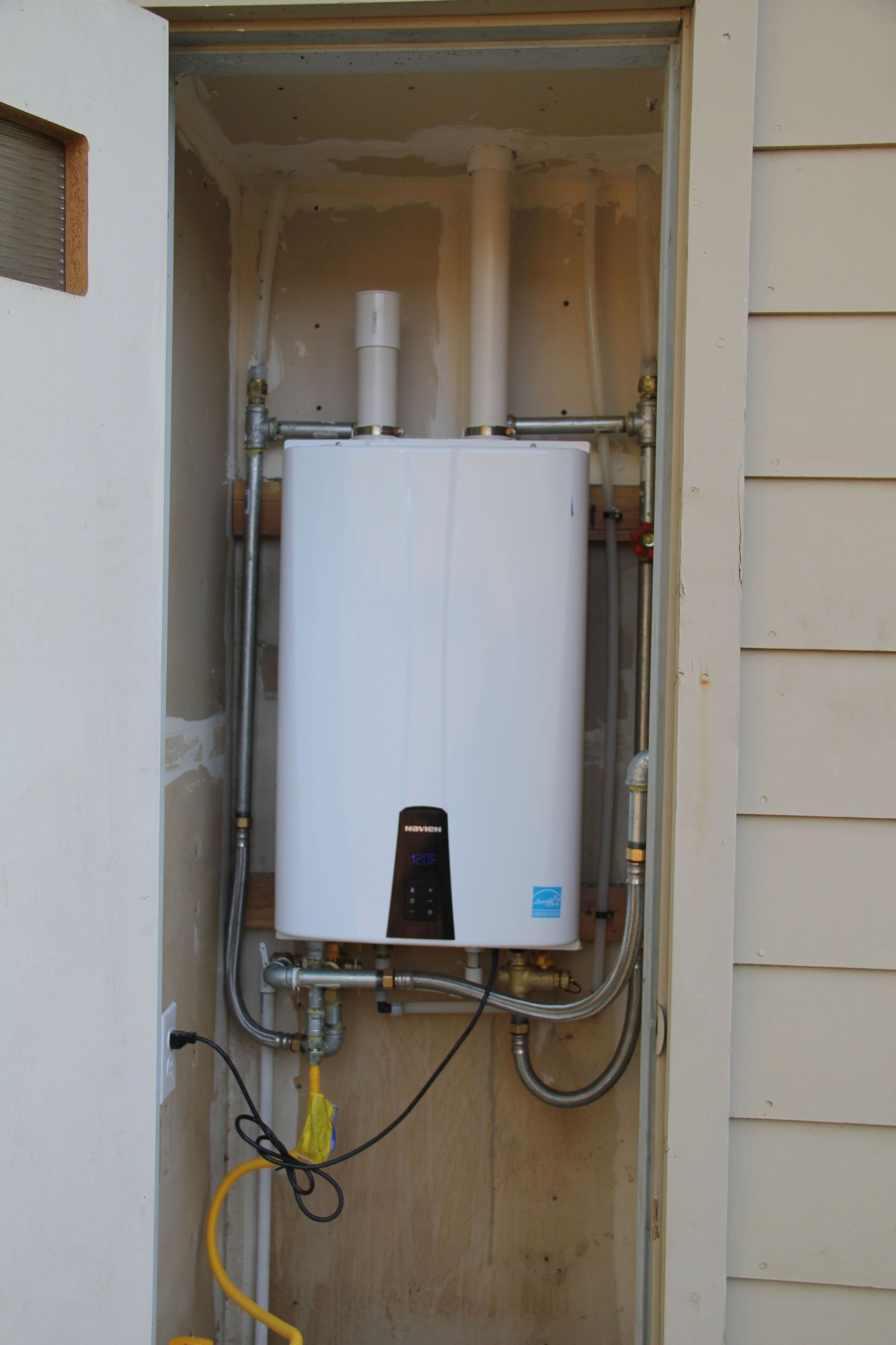 A white water heater with a blue sticker on it