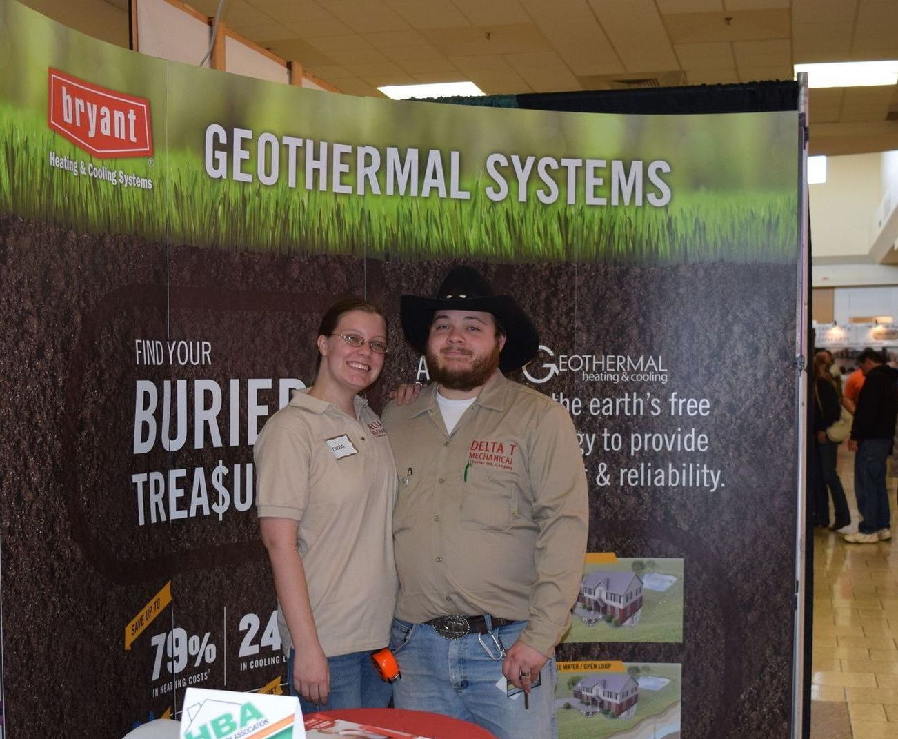 A man and woman standing in front of a sign that says geothermal systems