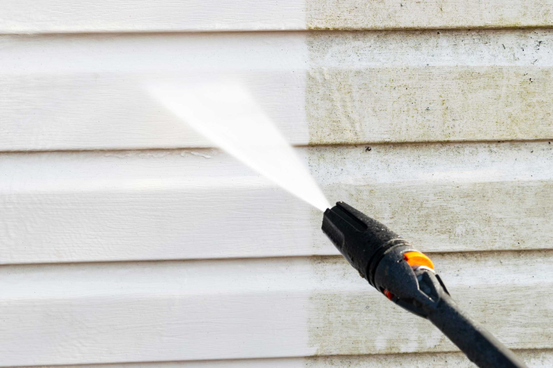 Pressure washing services removing mold and dirt from white vinyl house siding exterior wall. Pressure washing services removing mold and dirt from white vinyl house siding exterior wall.