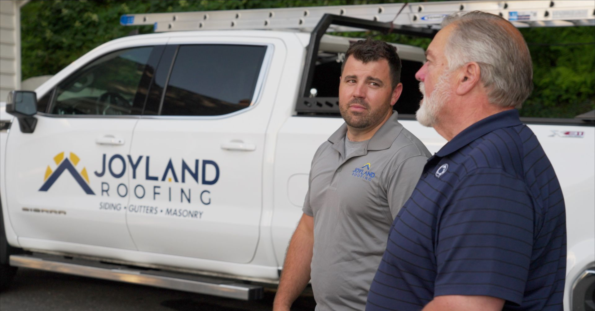 Two men next to a white pickup truck with