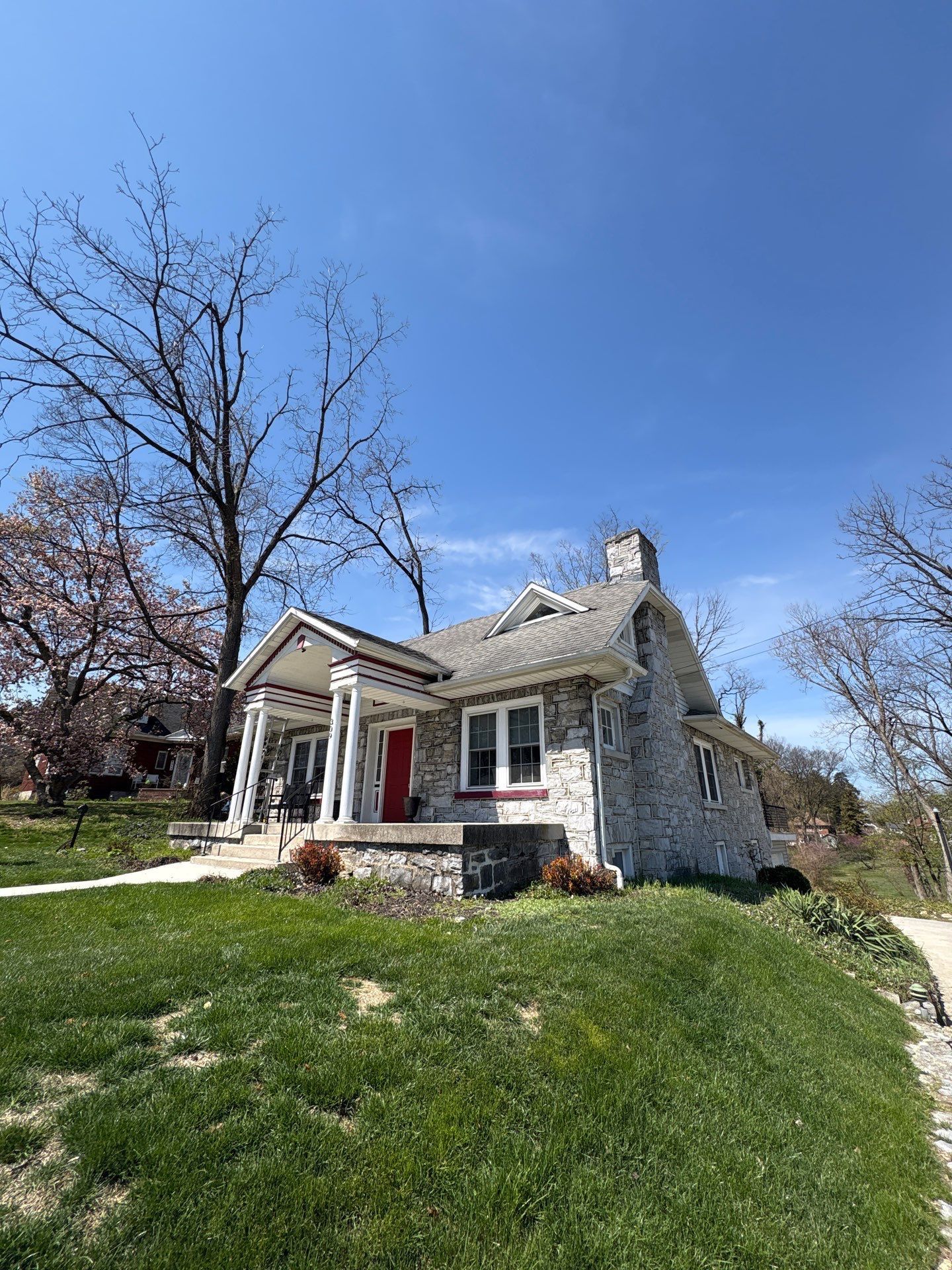 Asphalt shingle roof replacement completed on a stone home along 15th Street in New Cumberland, PA by Joyland Roofing.