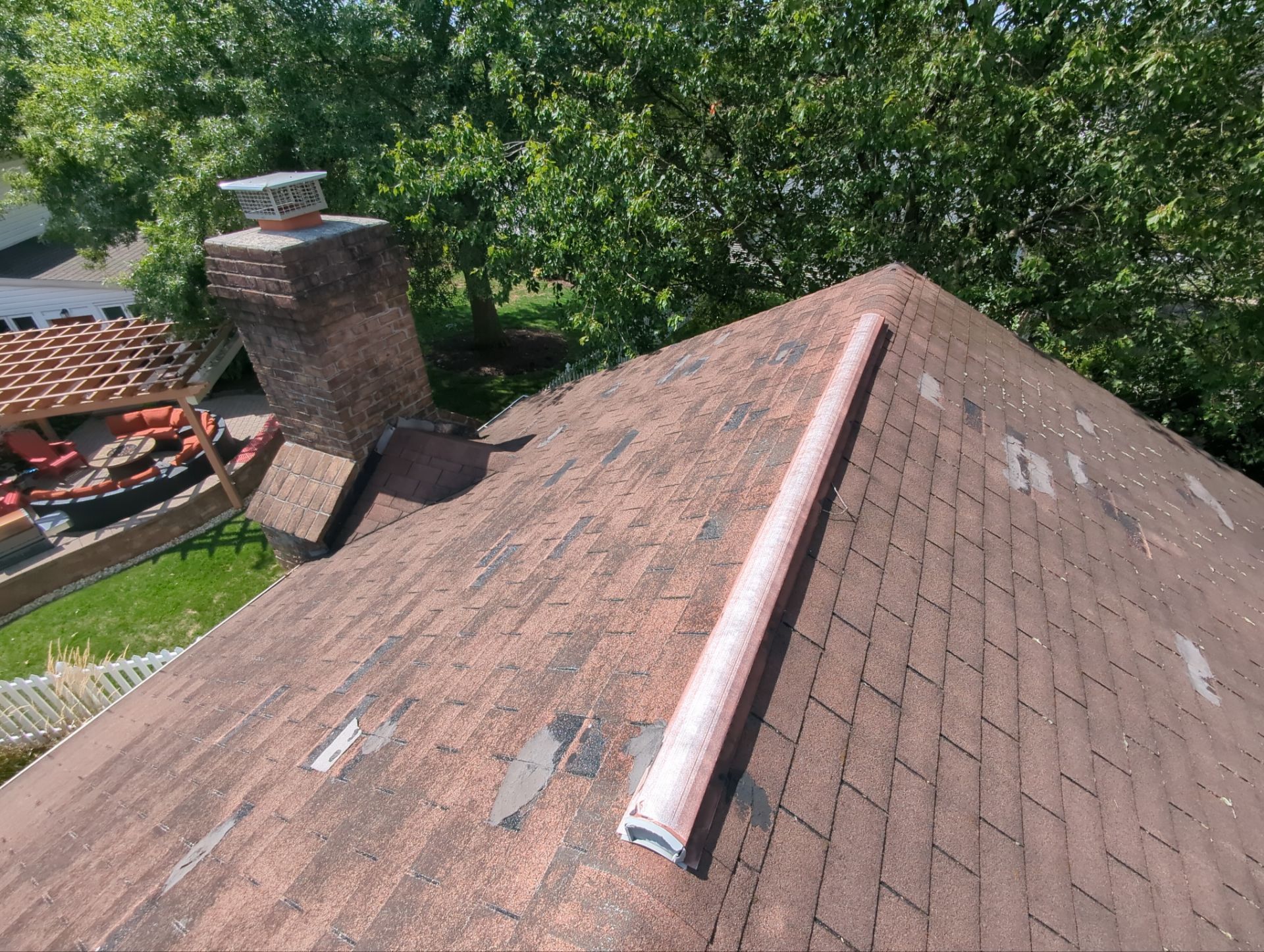 A residential asphalt shingle roof with widespread missing and deteriorated shingles documented in a Joyland Roofing replacement project