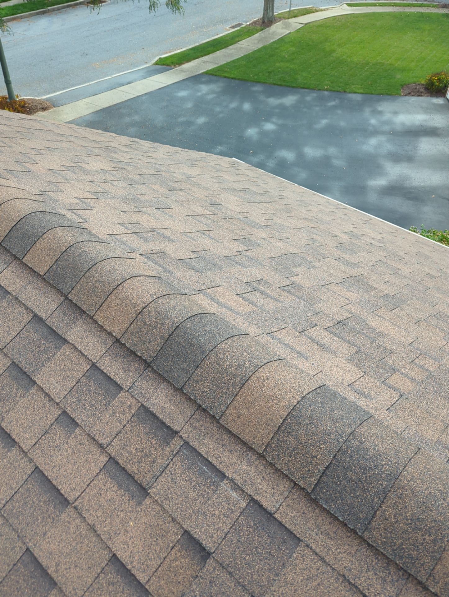 Completed asphalt shingle roof with new ridge cap shingles following a Joyland Roofing roof replacement project