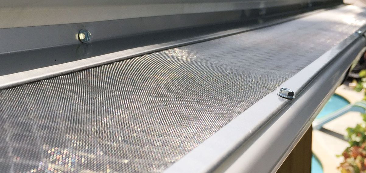 Close-up of a fine mesh insect screen along a window frame outdoors