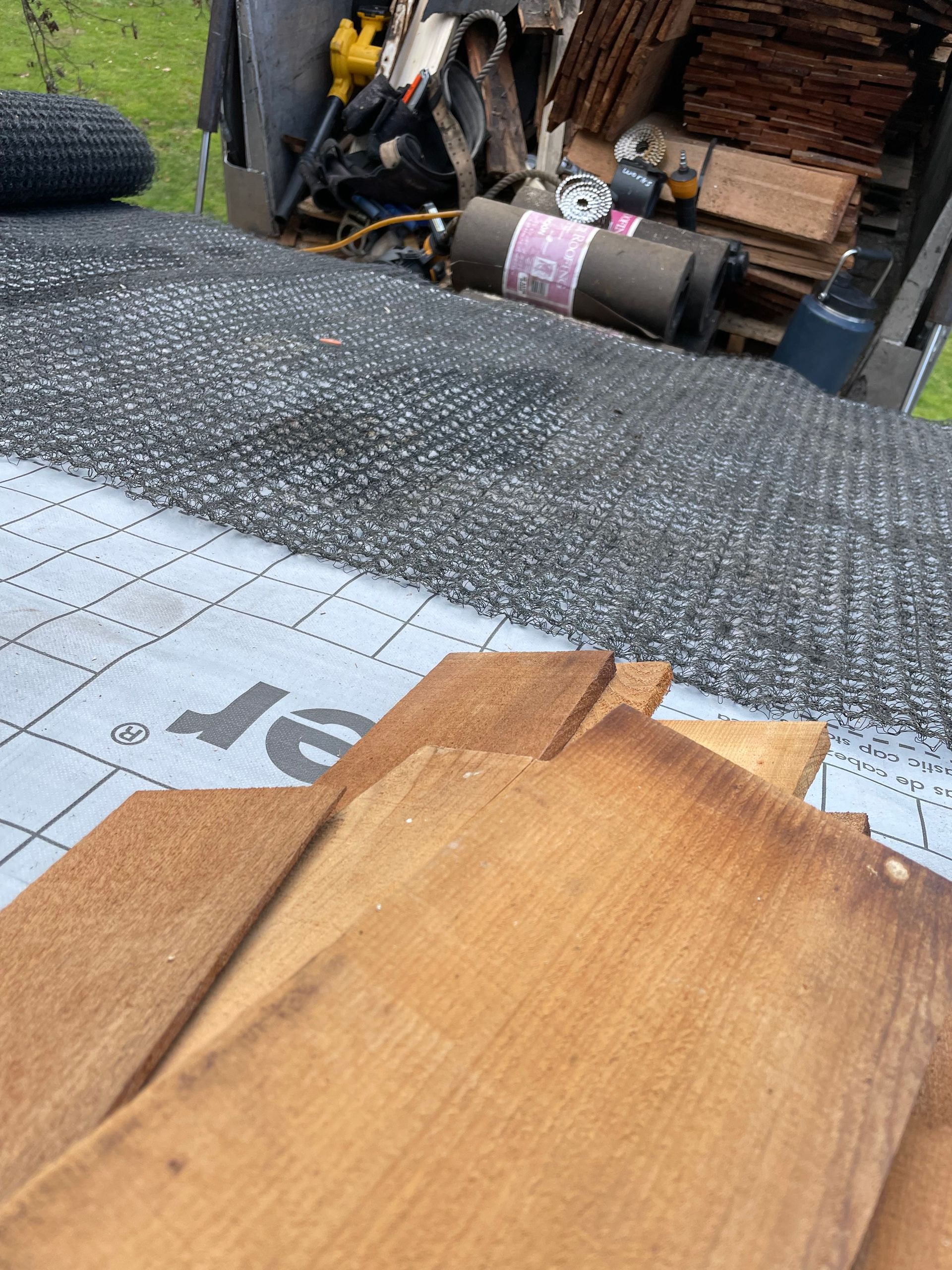 A hole in a weathered wooden surface, with broken planks surrounding it.