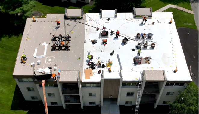 Joyland Roofing crew installing a white flat roof membrane system