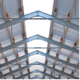 Interior view of a building roof structure with metal and wood beams.
