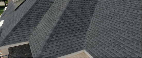 Overhead view of a dark gray shingled roof with multiple sections and angles.