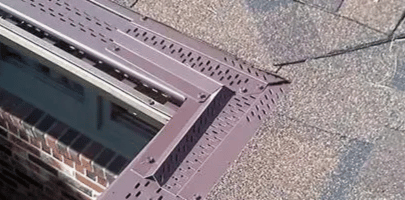 Aerial view of a rooftop with a skylight and gray gravel roofing.