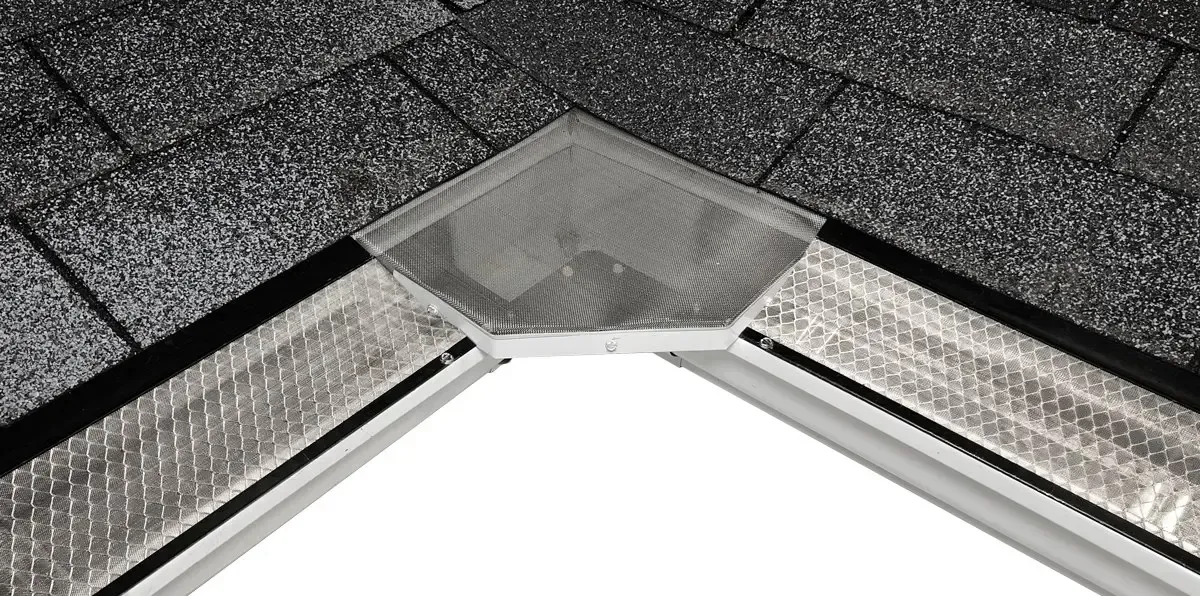 Close-up of a roof valley with gray shingles and a metal flashing vent at the peak