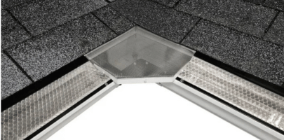 Close-up of a roof valley with gray shingles and a metal flashing vent at the peak