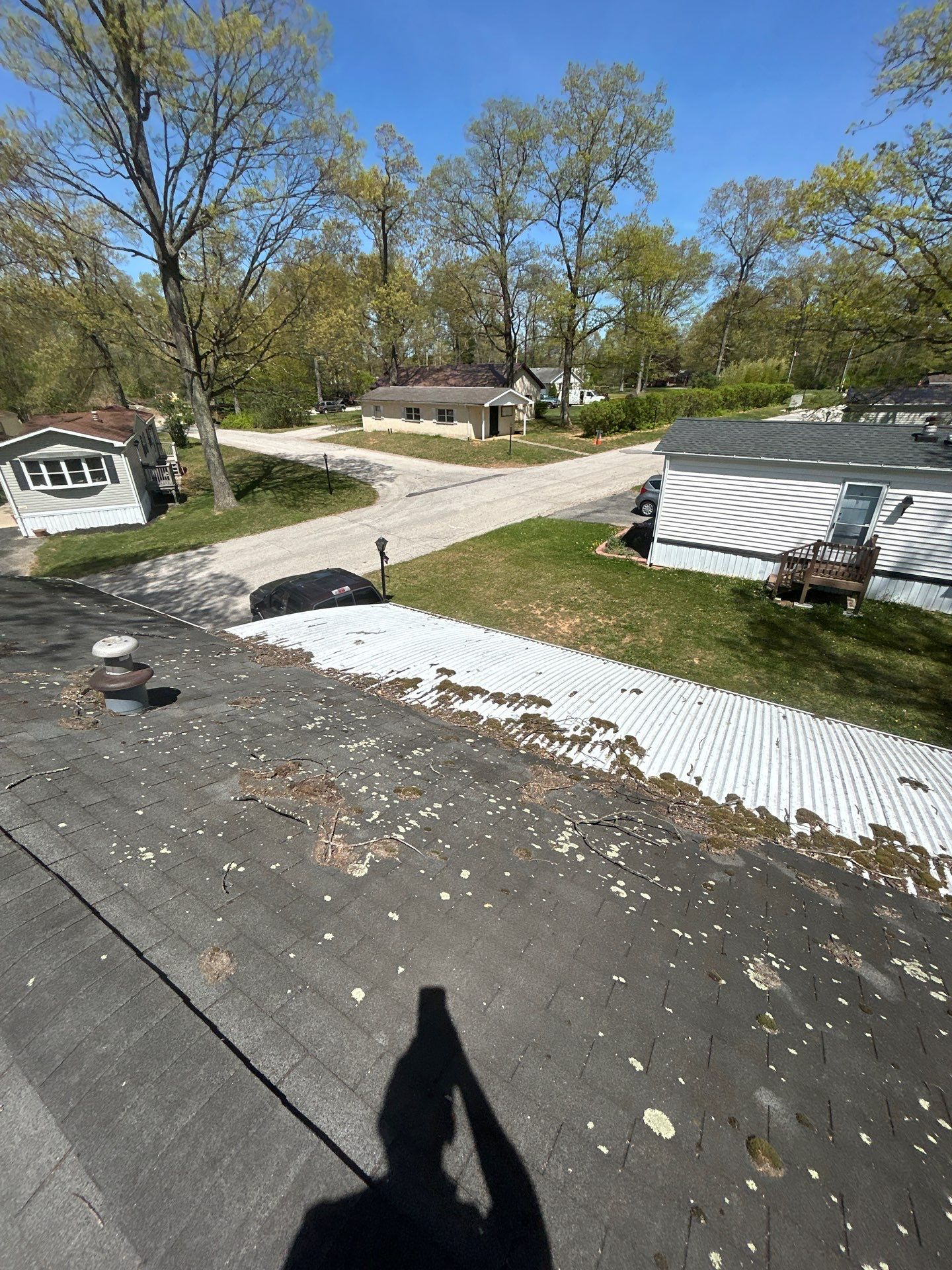 Asphalt shingle roof with visible moss, lichen, and debris buildup inspected on Oakwood Heights Drive in Stewartstown, PA.