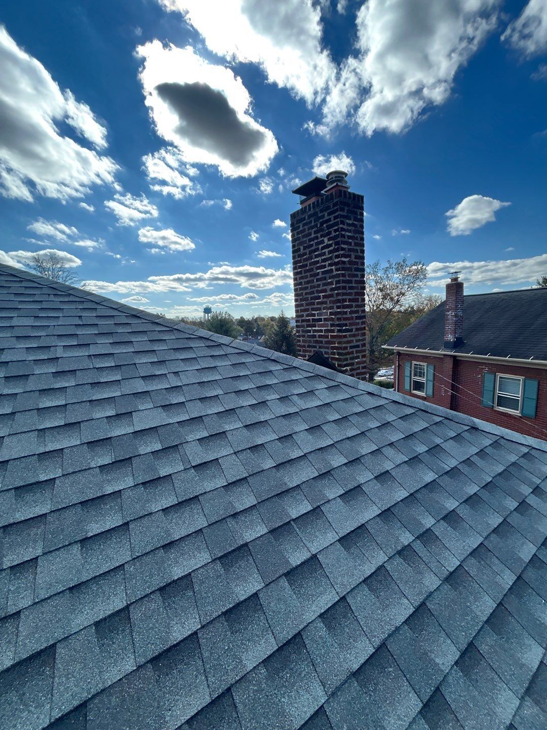 Completed asphalt shingle roof replacement with chimney flashing on North Franklin Street in Pottstown, PA