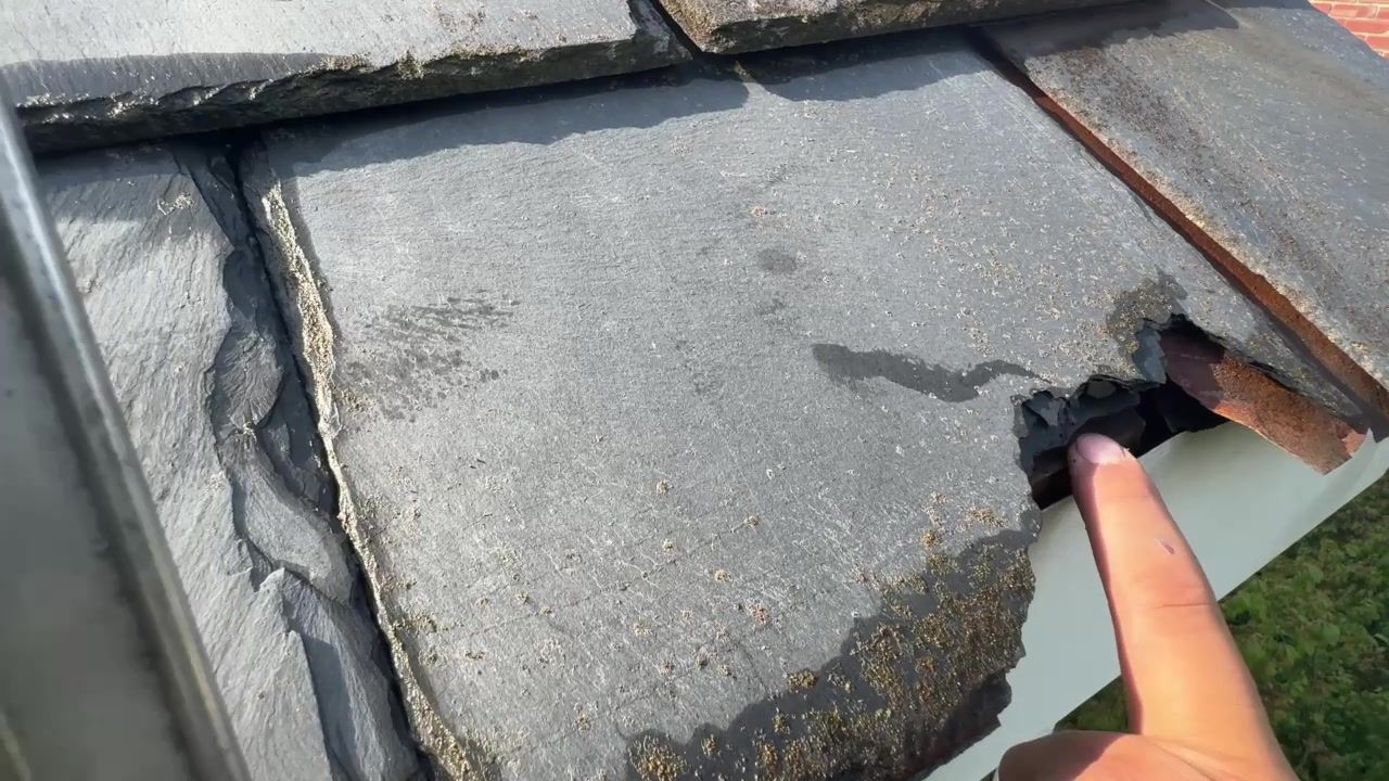 Broken storm-damaged slate tile near the edge of a roof in Lancaster, Pennsylvania