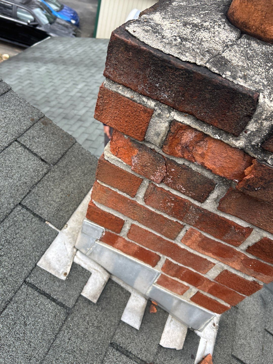 Close-up of a brick chimney with aging mortar and flashing inspected on Round Barn Road.