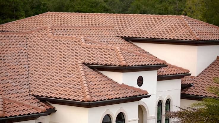 Tile-roofed Mediterranean-style house with white stucco walls and arched windows