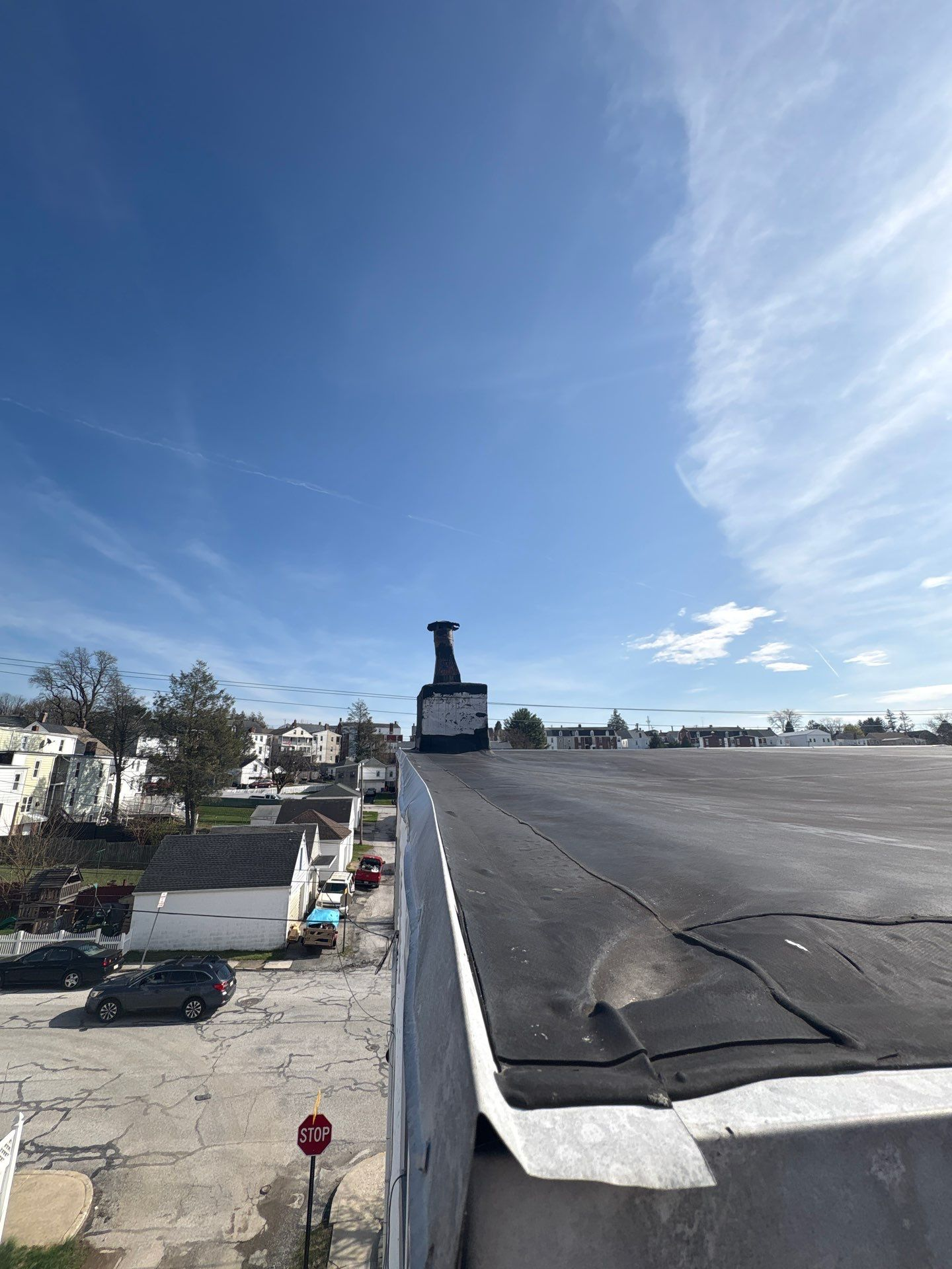Commercial flat roof inspection showing roof membrane, edge metal, and chimney flashing on West Maple Street in Red Lion, PA.