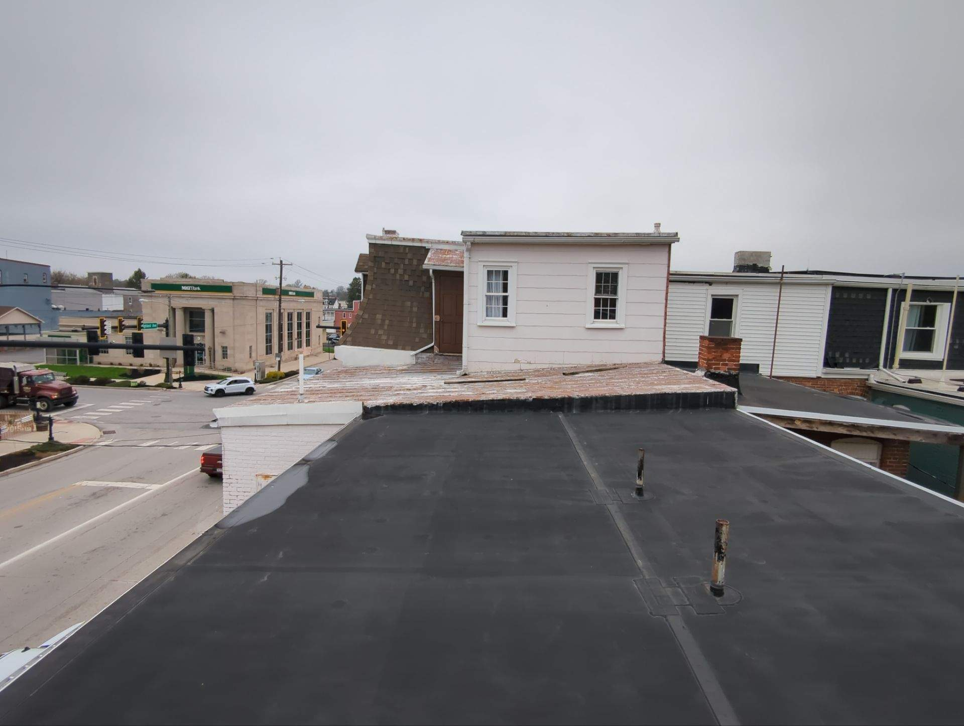 Flat rooftop overlooking neighboring buildings under an overcast sky