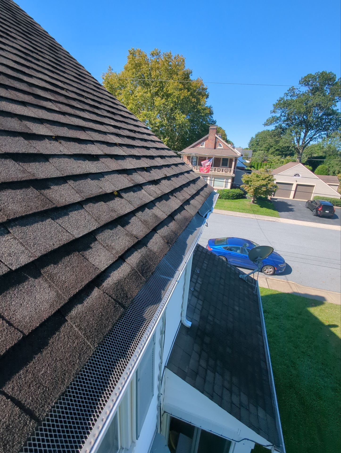 Asphalt shingle roof on Conestoga Street in New Holland, PA with gutter guards installed during a roof replacement inspection.