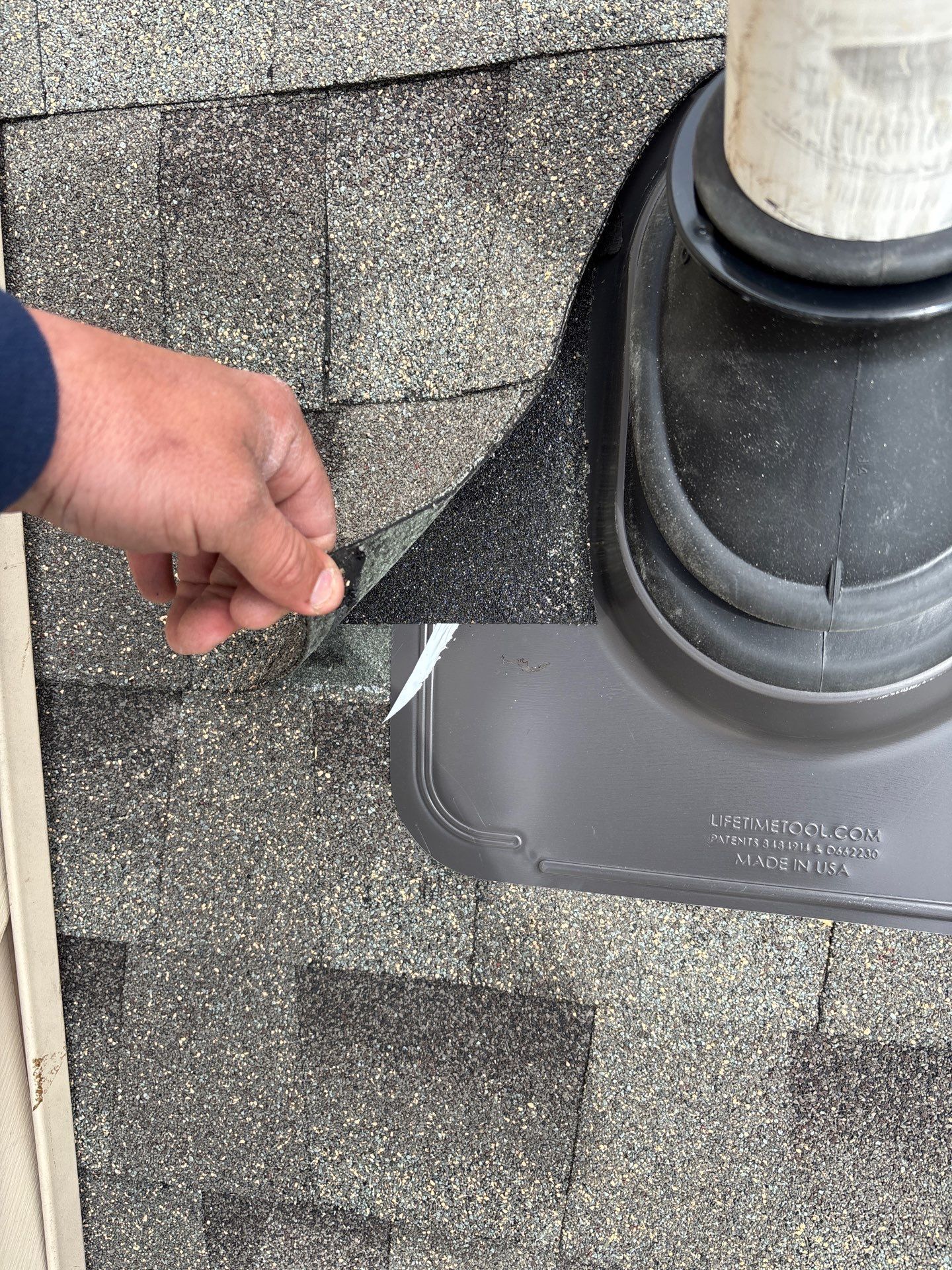 Roof inspection showing lifted asphalt shingles around a plumbing vent flashing on Dover Court in Morgantown, PA.