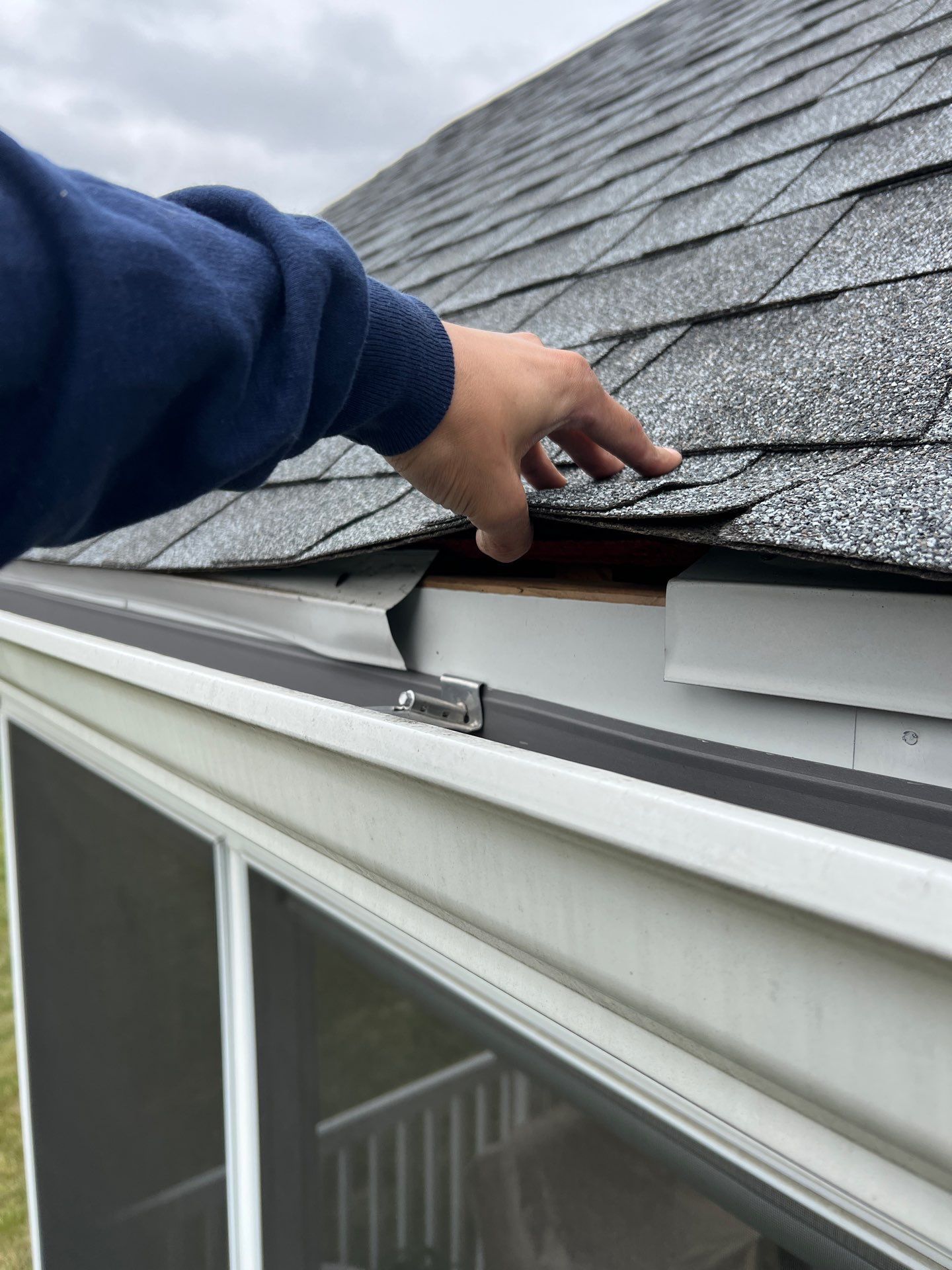 Roof edge inspection showing lifted shingles and exposed drip edge during a roof repair project on Ticonderoga Drive in East Petersburg, PA.