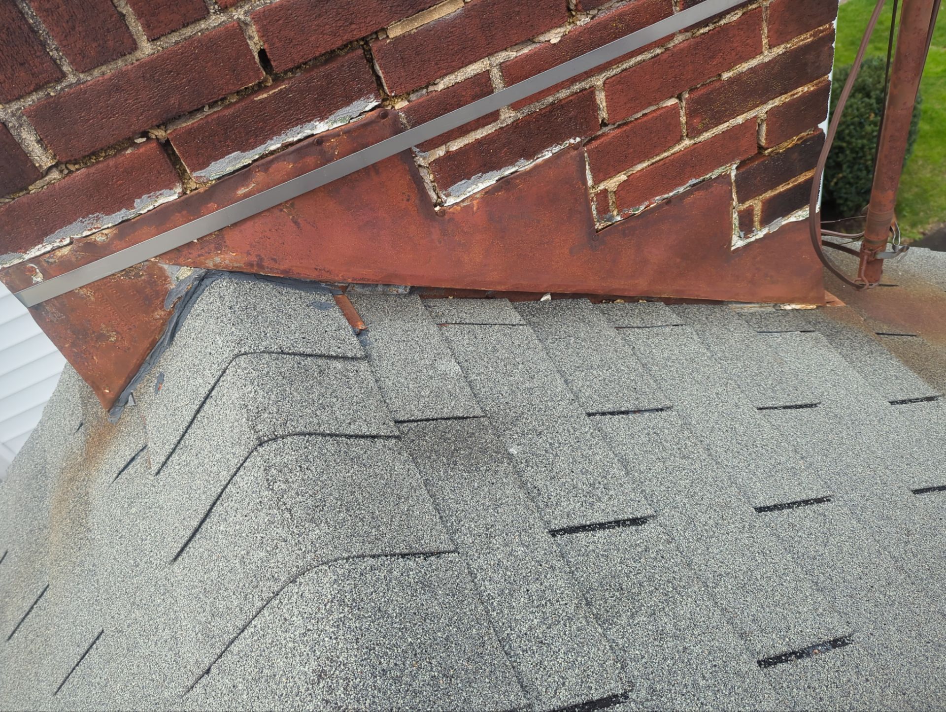 Chimney flashing repair process on an asphalt shingle roof on East Main Street in Shiremanstown, PA.