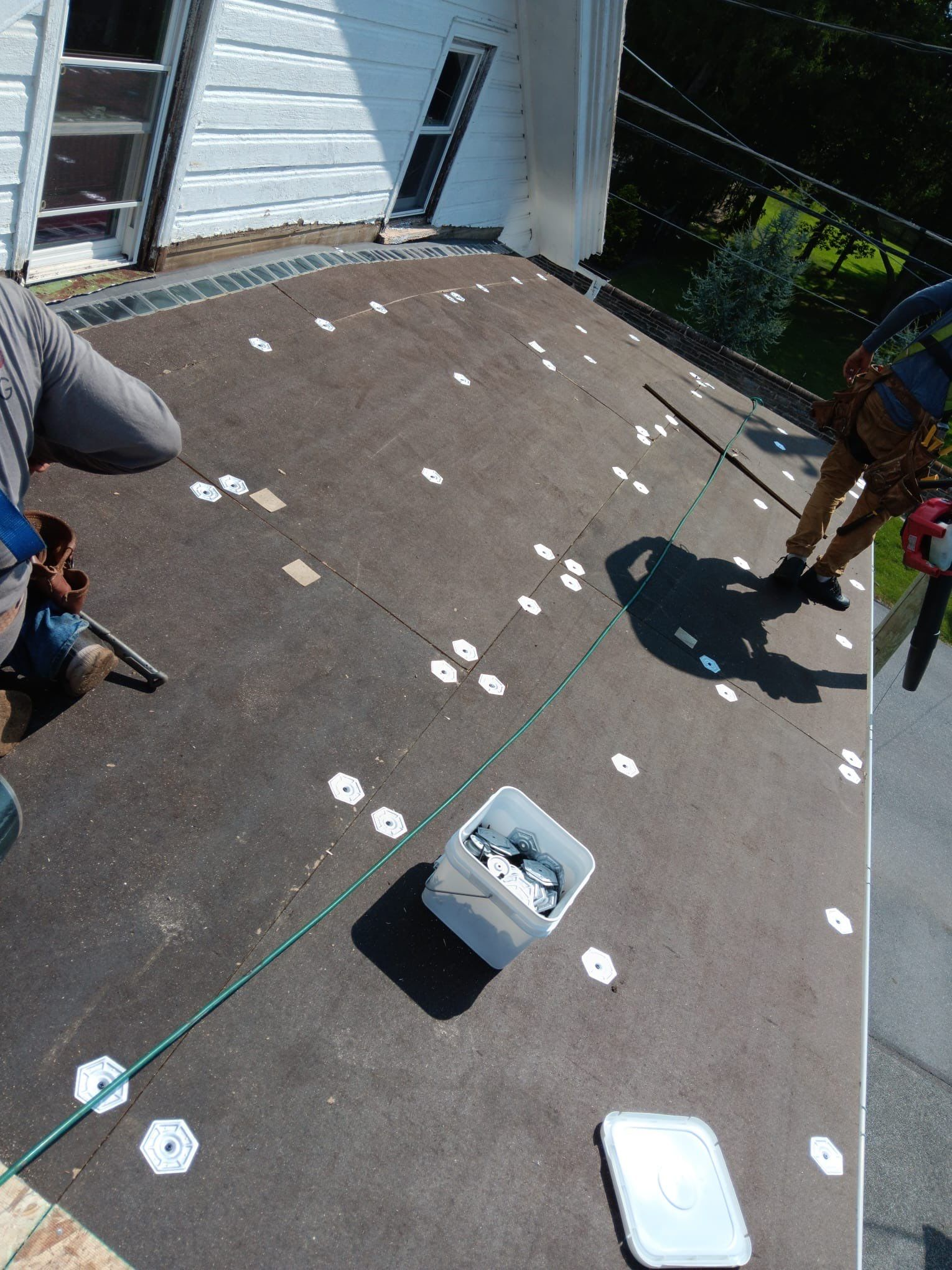 Joyland Roofing crew installing a new flat roofing system on a residential property on South Market Street in Schaefferstown, PA using insulation fasteners and underlayment.