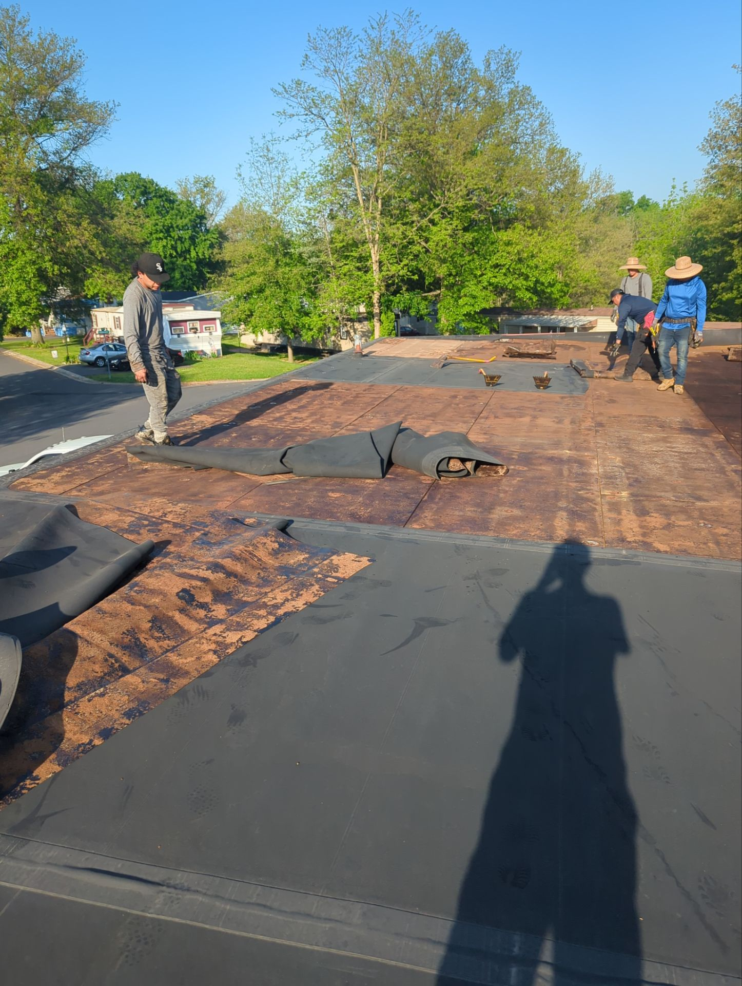Flat roof replacement in progress on a commercial-style building on Thunderbird Avenue in Dover, PA with new membrane roofing installation.