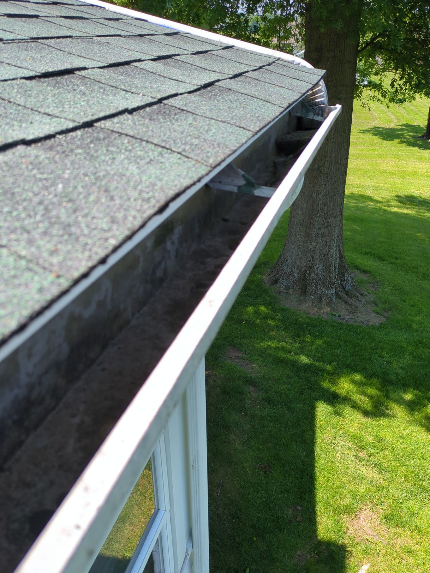 Gutter cleaning service removing debris from residential gutters on East Ridge Road in Dillsburg, PA by Joyland Roofing.