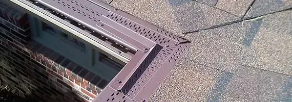 Aerial view of a rooftop with a skylight and gray gravel roofing.