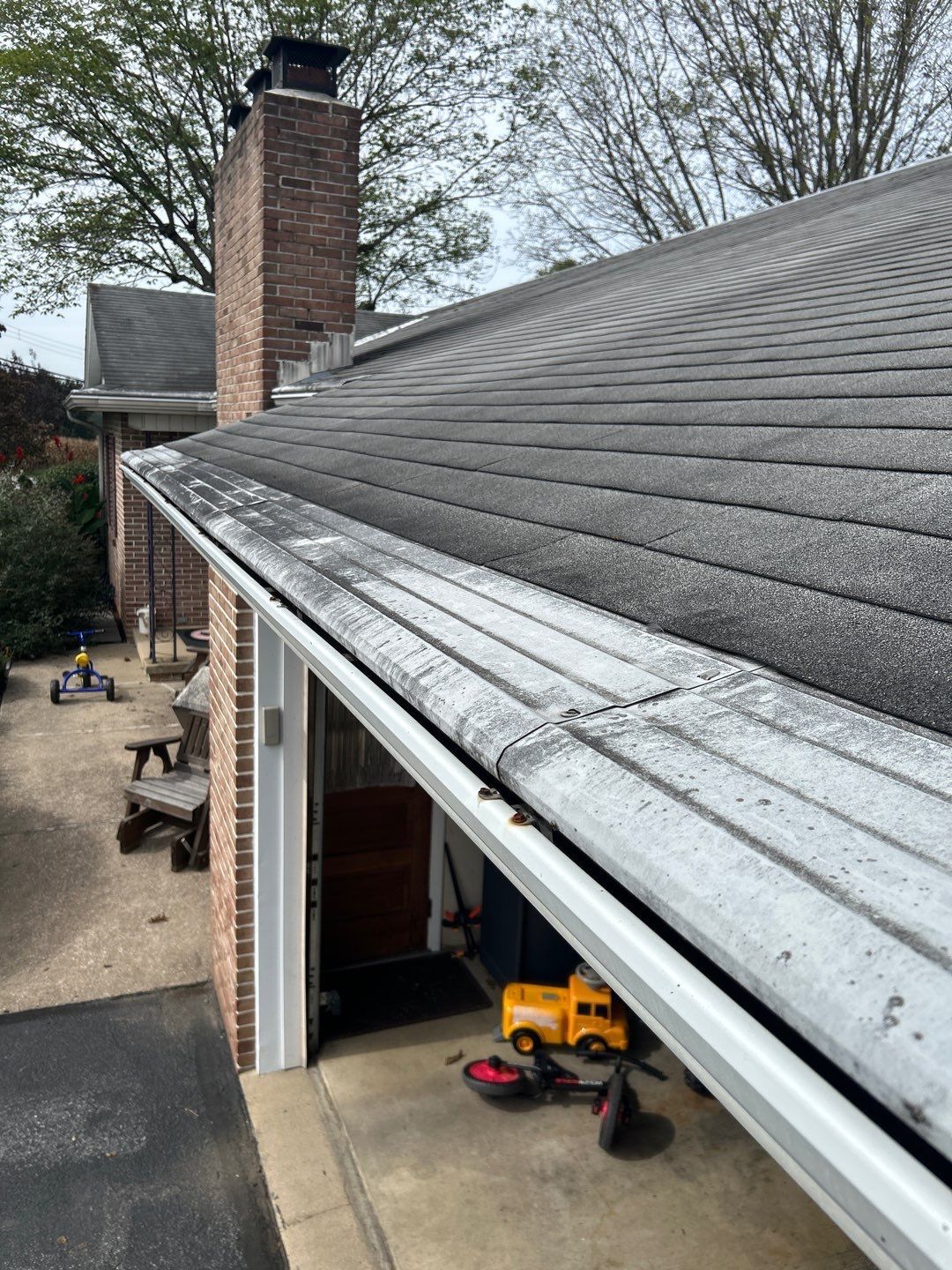 Professional inspection of gutter guards, roof edge, and chimney area on a residential home in Schaefferstown, PA.