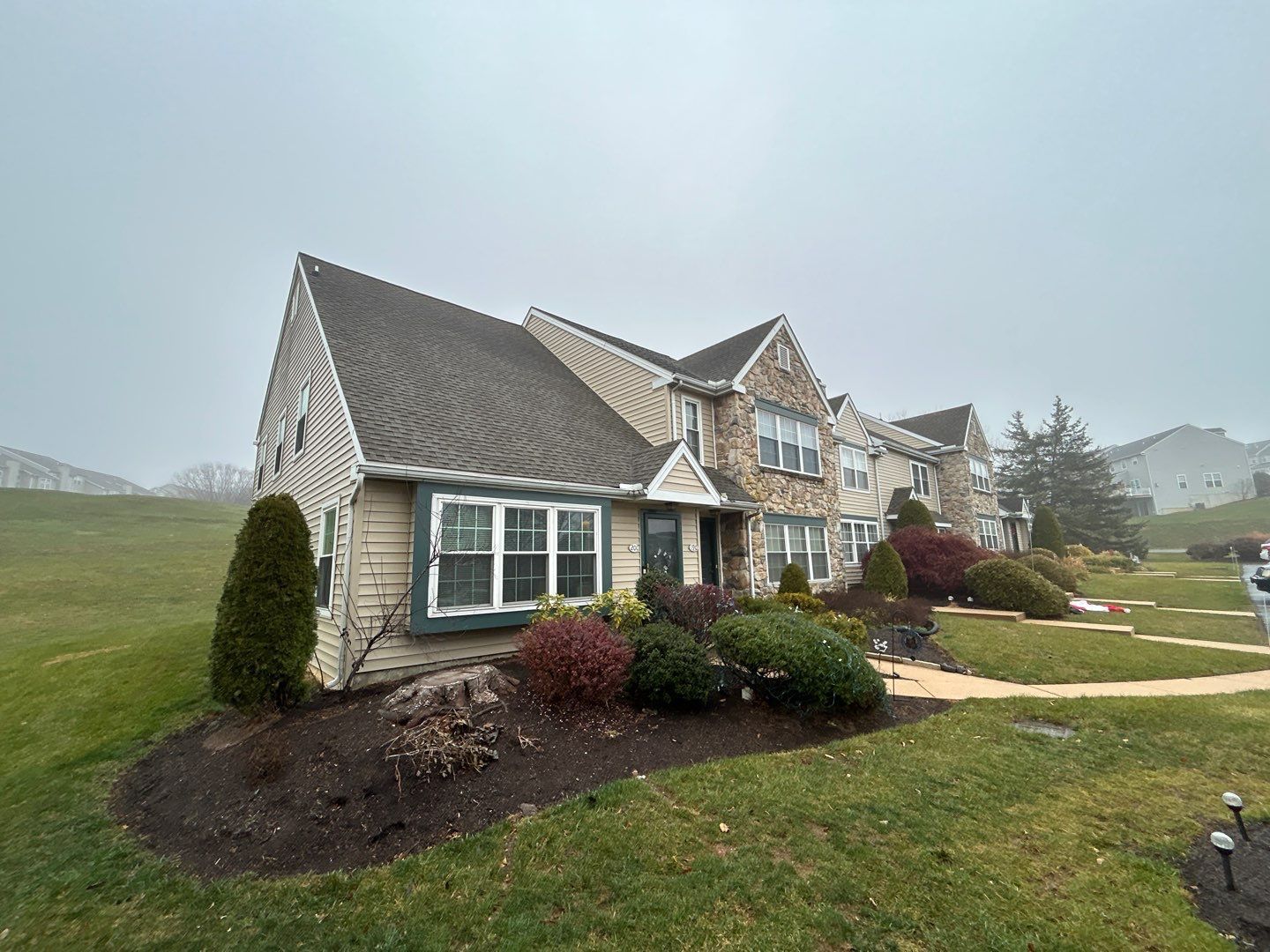 End-unit townhome with an asphalt shingle roof inspected for roof repairs on Hampton Court in Morgantown, PA.
