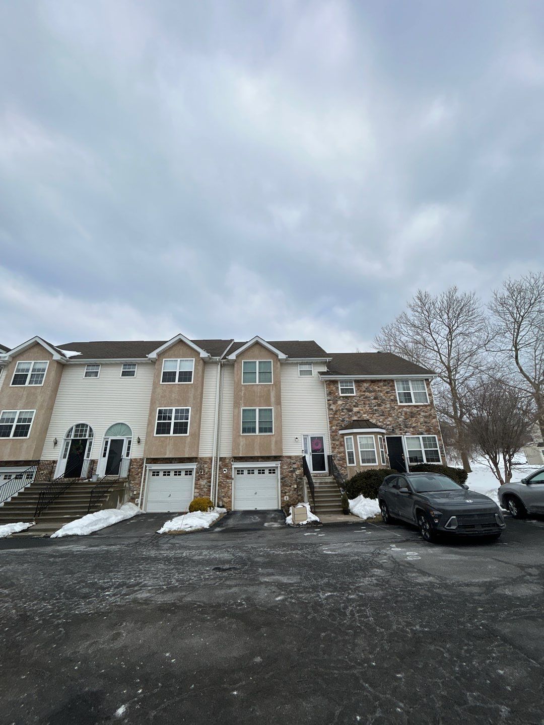 Townhome with an asphalt shingle roof scheduled for roof repair on Hampton Court in Morgantown, PA after winter weather exposure.