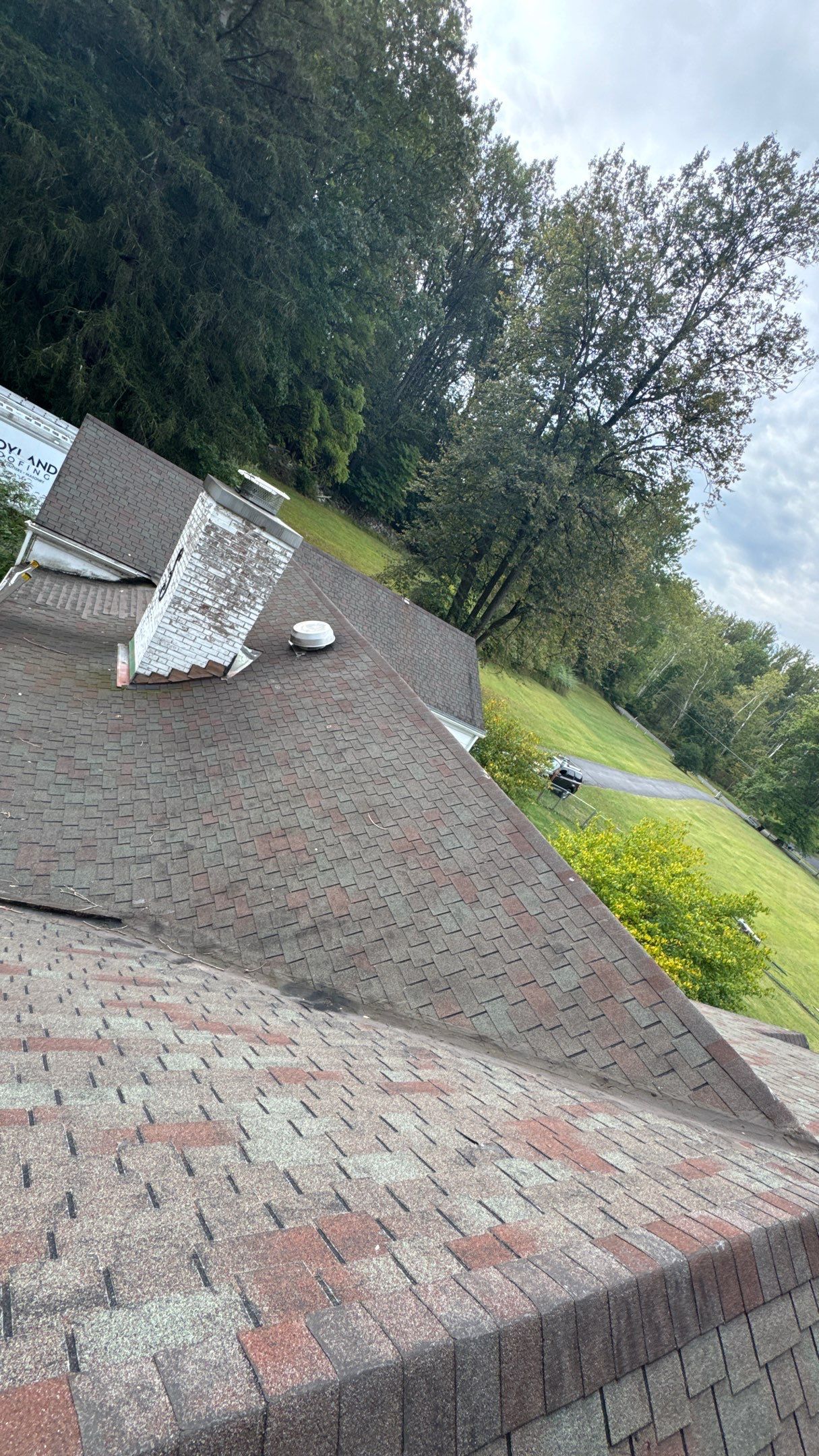 Overview of an asphalt shingle roof replacement on Heiligs School Road in Oley, PA with chimney and skylight.