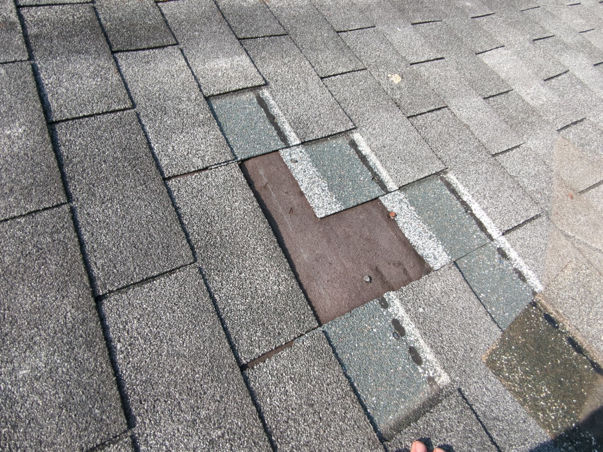 Asphalt shingle repair area on a residential roof along Hopewell Street