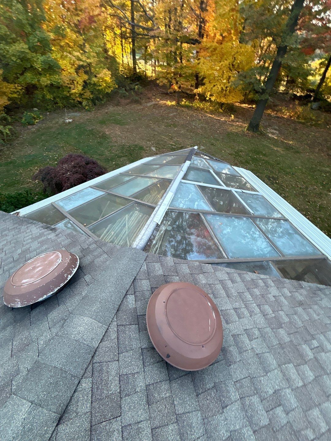 Professional roof flashing repair around a glass sunroom and asphalt shingle roof on Huntzinger Road by Joyland Roofing.