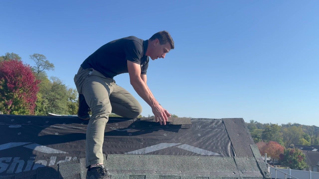 John Esh demonstrates the ridge-cap area at the peak of Joyland's roof display.