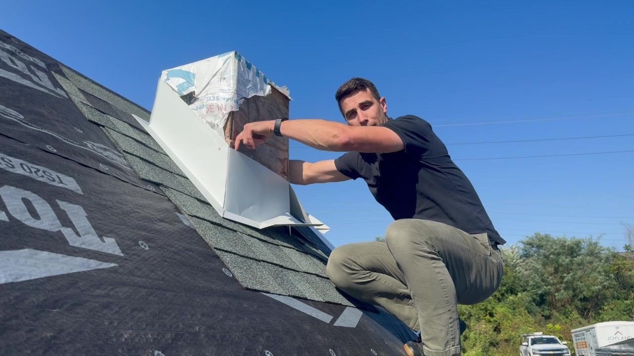 John Esh demonstrates flashing around a chimney on Joyland's roof display.