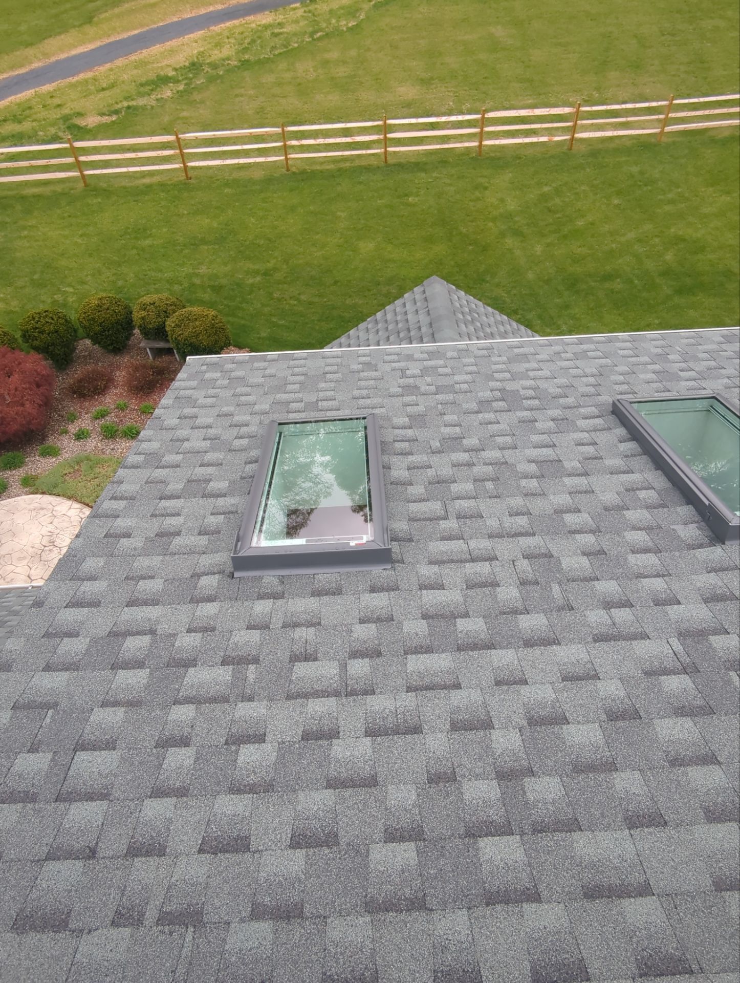 Completed architectural shingle roof replacement with new skylights on Ladybug Lane by Joyland Roofing.