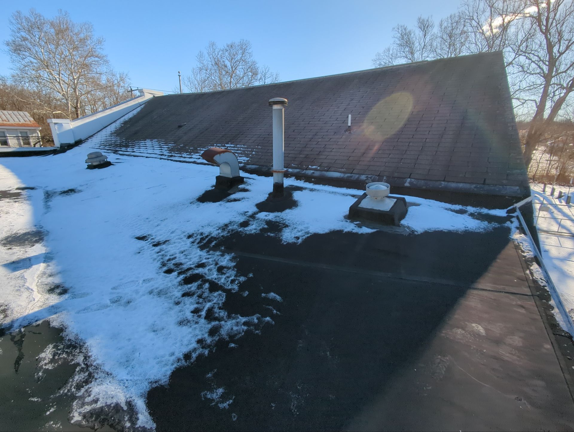 Flat roofing system on Main Street in Shoemakersville, PA inspected during winter with snow, roof vents, and drainage areas visible.